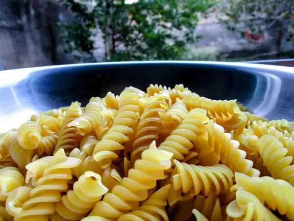 Mutfak masasındaki siyah kasede makarna.