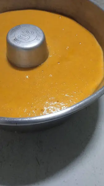 Metal bir tavada pişmeye hazır çiğ havuçlu kekin yakın plan fotoğrafı.