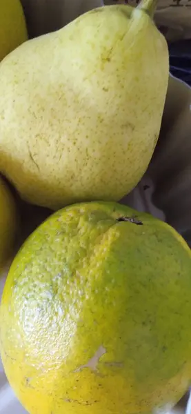 Taze yeşil armut ve olgun ekşi portakal.