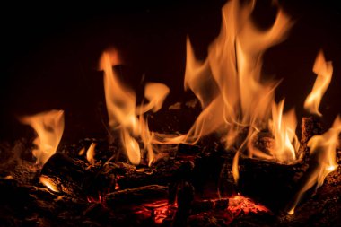 Şöminenin içinde odun odunları olan ateş alevleri sonbahar fotoğraflarında ateşin romantik fotoğrafları.
