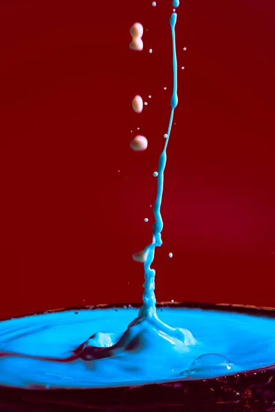 Zderzenie Ruchomych Kropli Wody Kolorze Niebieskim Fioletowym Czerwonym Tle Tworząc — Zdjęcie stockowe