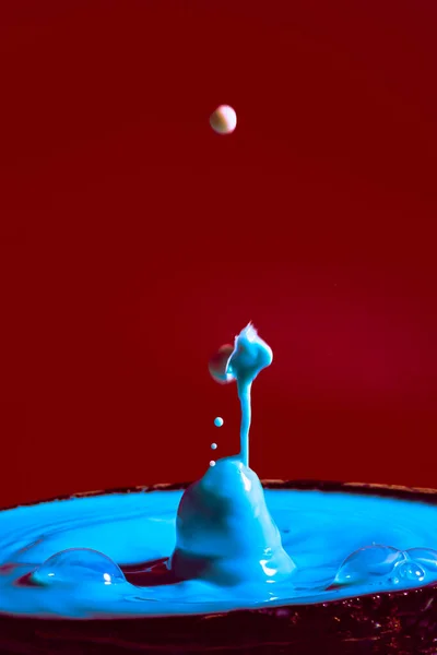 collision of moving water drops of blue color on a purple red background forming figures and waves when falling and colliding with each other photography and high resolution images relaxation photography
