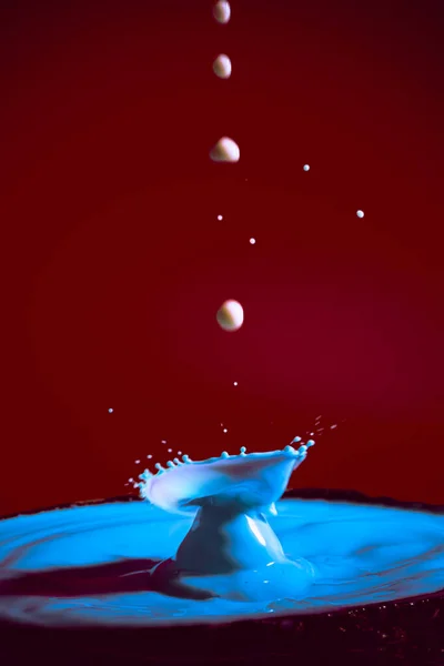collision of moving water drops of blue color on a purple red background forming figures and waves when falling and colliding with each other photography and high resolution images relaxation photography