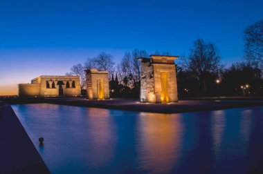 sunset view at the temple of debod in the city of madrid with reflections in the water urban photography