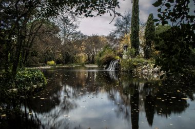 pond with silk water in the fall in the capricho park of the city of madrid urban photography