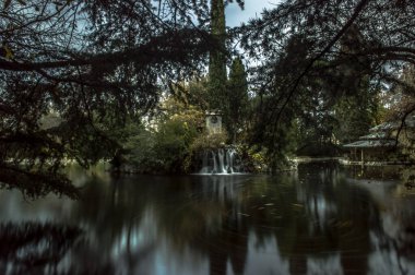 pond with silk water in the fall in the capricho park of the city of madrid urban photography