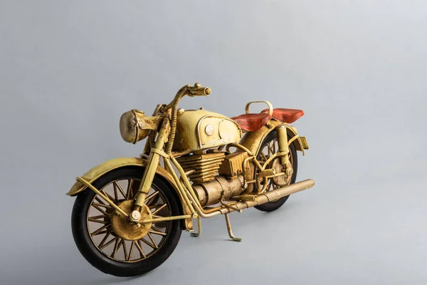Collectible toy motorbike in gold color with brown seat