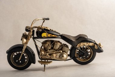 The photograph of a black motorcycle with a colored seat. Vintage metal collection figures.