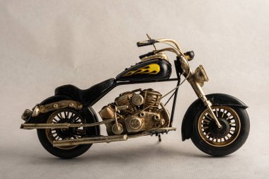 The photograph of a black motorcycle with a colored seat. Vintage metal collection figures.