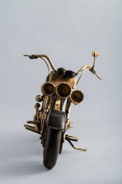 The photograph of a black motorcycle with a brown seat. Vintage metal collection figures.