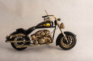 The photograph of a black motorcycle with a brown seat. Vintage metal collection figures.