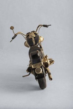 The photograph of a black motorcycle with a brown seat. Vintage metal collection figures.