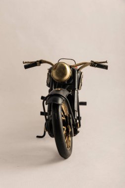 The photograph of a black motorcycle with a brown seat. Vintage metal collection figures.