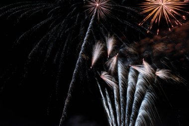 Yeni yıl şenlikleri, yeni yıl arifesi. Karanlık gökyüzündeki havai fişeklerin renkleri, göl ışığı şenliklerinin suyuna yansıyan renkli roketler.