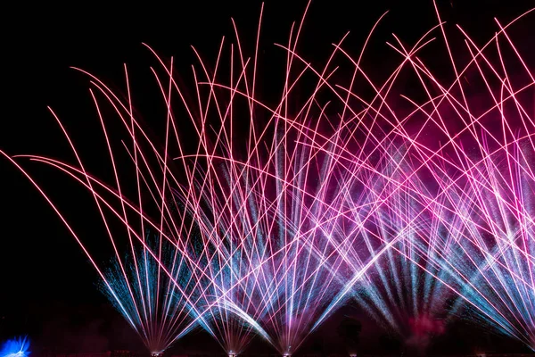 新年快乐新年庆祝活动新年前夕 在漆黑的夜空中 烟火燃放着五彩缤纷的烟火 彩色火箭的图像映衬在湖光欢庆的水面上 — 图库照片