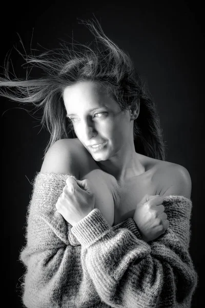 黒と白の若い女性の肖像画寒さを感じます彼女のセーターを保持します — ストック写真