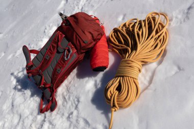 Kırmızı sırt çantası ve sarı halat karlı bir yamaçta yatıyor, Avusturya, Alpler, Dachstein. Yüksek kalite fotoğraf