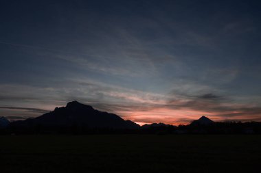 Avusturya 'nın Salzburg yakınlarındaki Alp Dağları' nın parlak pembe bir günbatımında rahatlaması. Yüksek kalite fotoğraf