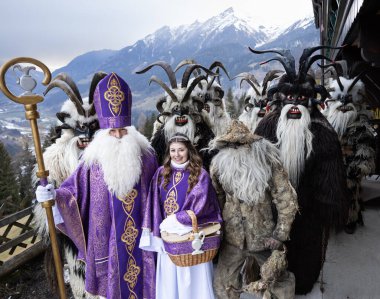Costumed procession of St. Nicholas, an angel and kramus in a mountainous region, Austria, Salzburg. High quality photo clipart