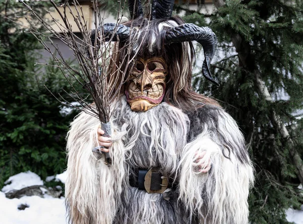 Portrait of a boy in a krampus costume, animal skin, horns and a wooden mask, Austria, Salzburg. High quality photo
