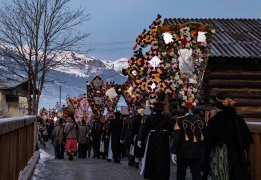AUSTRIA, GASTEIN - January 1, 2023: Procession of perchten against the backdrop of the Alpine mountains. High quality photo