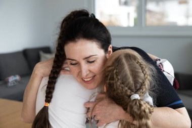 Beautiful happy mother hugs two daughters with long hair. High quality photo