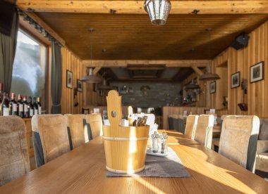Hall of a sunlit Alpine restaurant with wooden and leather trim, Austria, Salzburg, Gastein Valley. High quality photo