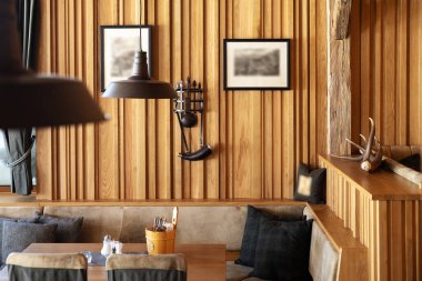 Part of the hall of the Austrian restaurant, lined with wood, with soft sofas and pendant lamps. High quality photo