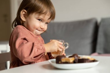 Küçük kız yemek masasında otururken flört ediyor. Yüksek kalite fotoğraf