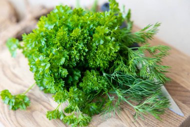 Tahta kesme tahtasının üzerinde taze ve parlak yeşiller var. Sağlıklı beslenme kavramı. Yüksek kalite fotoğraf