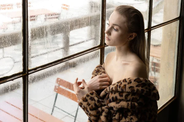 Молода Дівчина Шубою Плечах Стоїть Біля Мокрого Вікна Дивиться Дощ — стокове фото