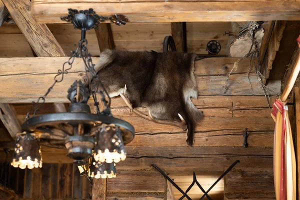 An original metal lamp and animal skin under the ceiling of a rustic Austrian restaurant. High quality photo