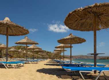 Yunanistan 'ın Girit kentinin güney kıyısında turizm sezonunun başında kumlu Vai plajı ve boş şemsiyeler. Yüksek kalite fotoğraf