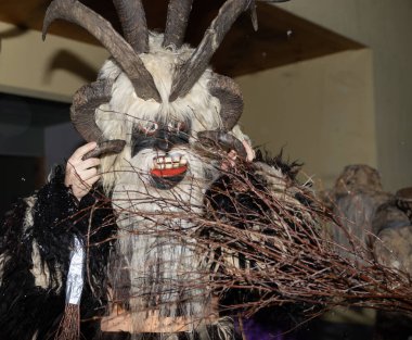 Efsanevi Krampus, bir Noel şeytanı, hayvan derisi içinde, ellerinde boynuz ve çubuklarla, Avusturya, Gastein. Yüksek kalite fotoğraf