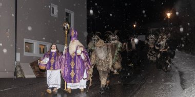 Aziz Niklas ve efsanevi Krampus 'un Avusturya' daki ıssız bir gece caddesinde geçit töreni. Yüksek kalite fotoğraf