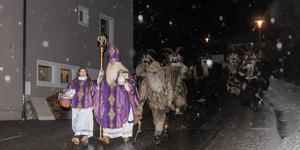 Aziz Niklas ve efsanevi Krampus 'un Avusturya' daki ıssız bir gece caddesinde geçit töreni. Yüksek kalite fotoğraf