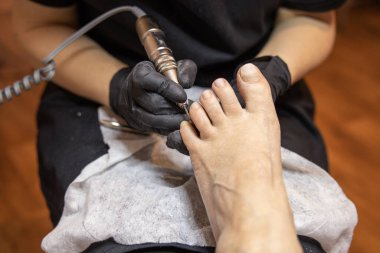 Pedikür uzmanı prosedürü özel ekipmanların yardımıyla gerçekleştirir. Yüksek kalite fotoğraf