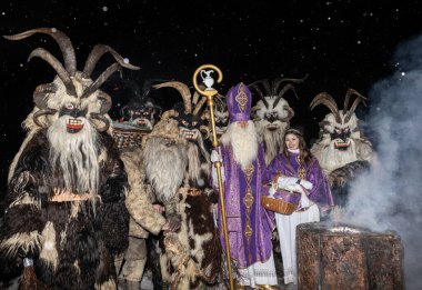 Aziz Niklas önderliğindeki bir grup Krampus Avusturya, Gastein 'da dumanlı bir kütükte duruyor. Yüksek kalite fotoğraf