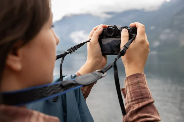 stock image A female tourist takes a picture with a lake on camera, the concept of outdoor recreation, Hallstatt, Austria. High quality photo