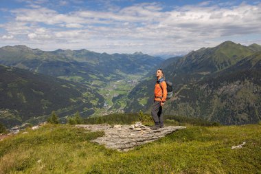 Sırt çantalı gri saçlı adam dağda dikiliyor ve Avusturya 'ya doğru ilerlemeye çalışıyor. Yüksek kalite fotoğraf