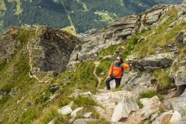Adam kayalık patikada durmuş ve Avusturya 'nın kayalık arka planında dinleniyormuş. Yüksek kalite fotoğraf