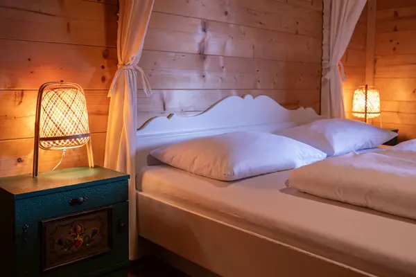 Çift kişilik yataklı bir yatak odası, orijinal gece lambalı komodinleri, Avusturya 'da bir otel odası. Yüksek kalite fotoğraf