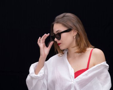 Beyaz gömlekli, omuzları açık güneş gözlüklü, güzel kızlar profili olan güzel bir kız. Yüksek kalite fotoğraf