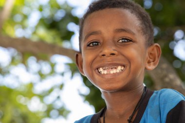 INDONEZYA, ISLAND KRI - 27 HAZİRAN 2024: Parlak gözlü Papuan çocuk sağlıksız dişlerini gösteriyor. Yüksek kalite fotoğraf