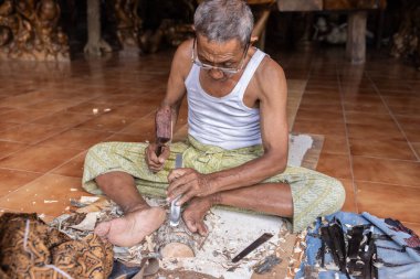 INDONEZYA, BALI - 8 Şubat 2024: Yaşlı bir Endonezyalı gemi için odun işliyor. Yüksek kalite fotoğraf
