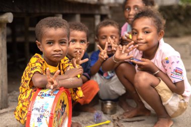 INDONEZYA, ISLAND KRI - 25 HAZİRAN 2024: Küçük Papualı çocuklar bir sokak fotoğrafçısı için poz veriyor. Yüksek kalite fotoğraf