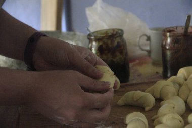 Genç bir Ukraynalı kız köylü masasında simit yapıyor.