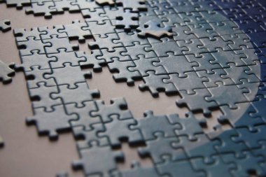 Karanlık bir arkaplanda bir yapboz parçasının bulmaca parçaları