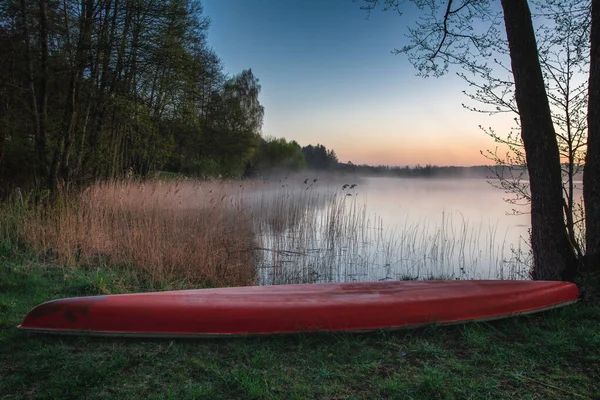 Gowidliskie Gölü ve bir kano - şafak vakti Kashubia, Polonya