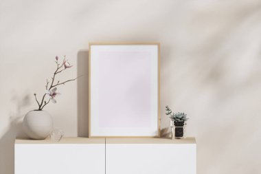 Üç boyutlu boş beyaz sanat çerçevesini bej duvar kağıdına, zarif beyaz ahşap büfeyle vazolarda moda çiçek yaprakları, beyaz perdeler, sabah güneşi. Ev, Alıntılar, Poster.